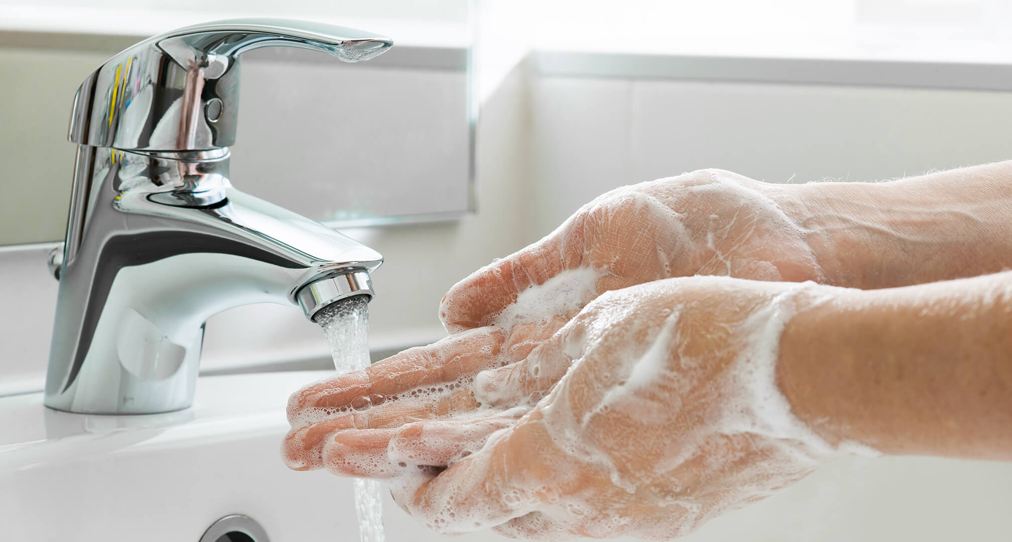 tvätta händerna med tvål under kran