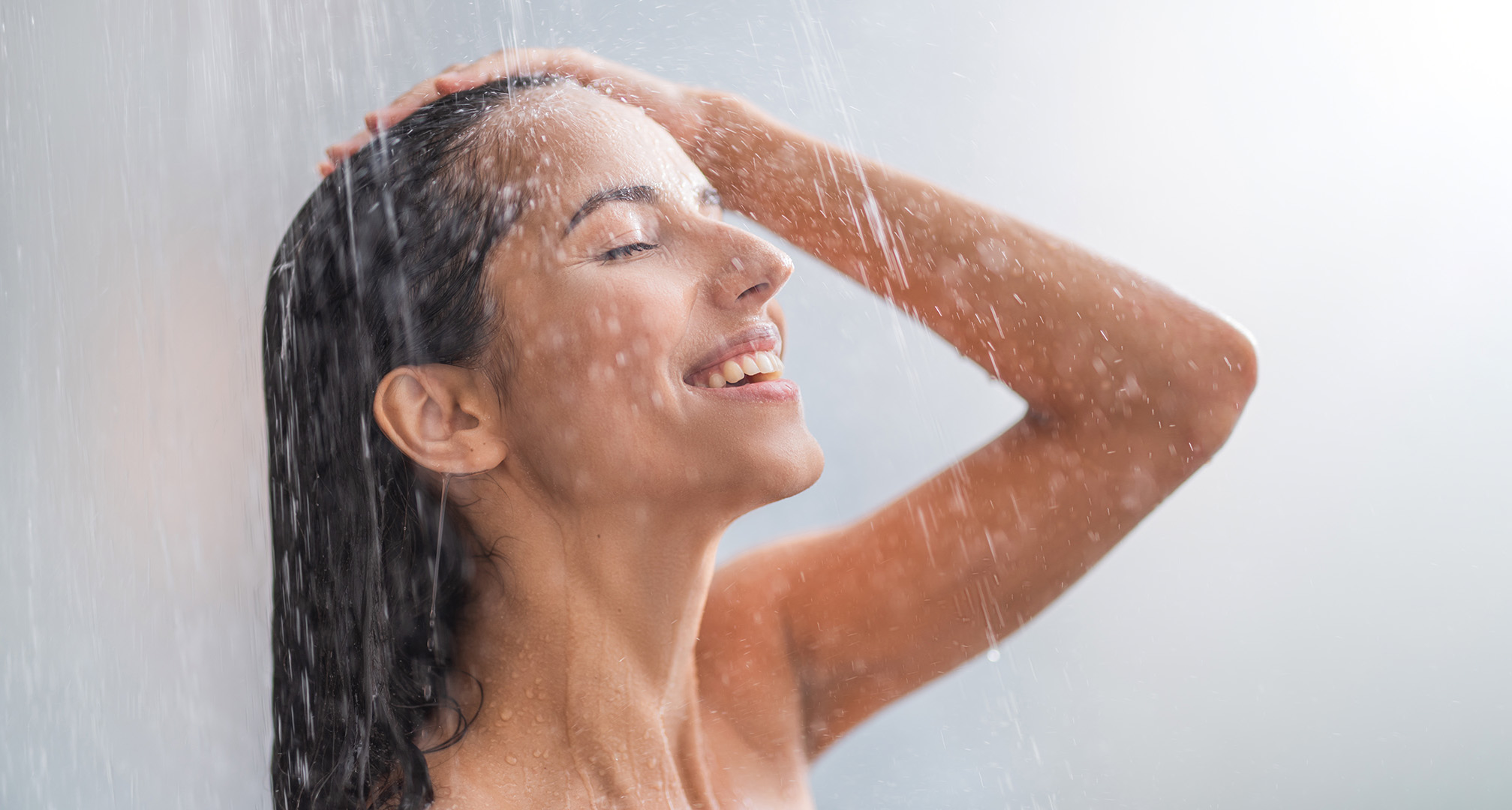 en persons ansikte under ett duschmunstycke