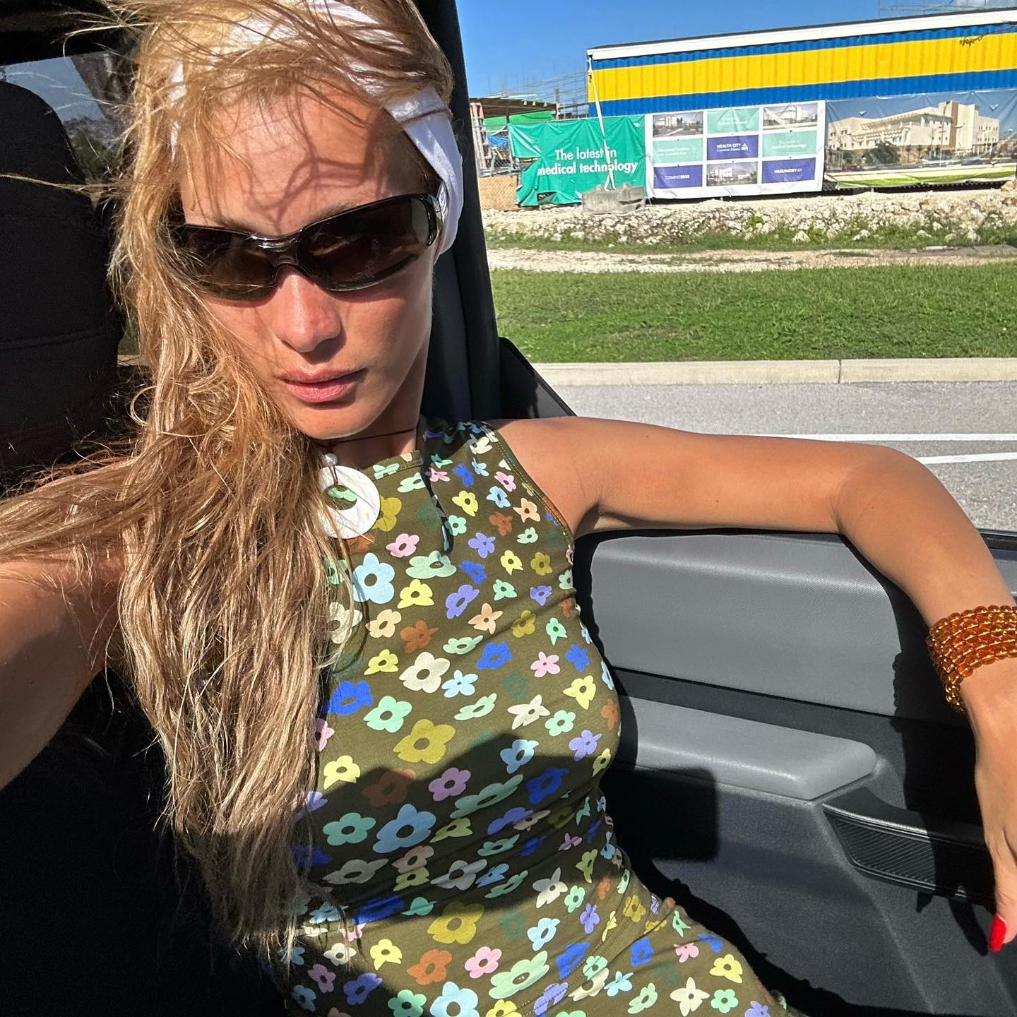 Bella Hadid i sportglasögon som sitter i en bil