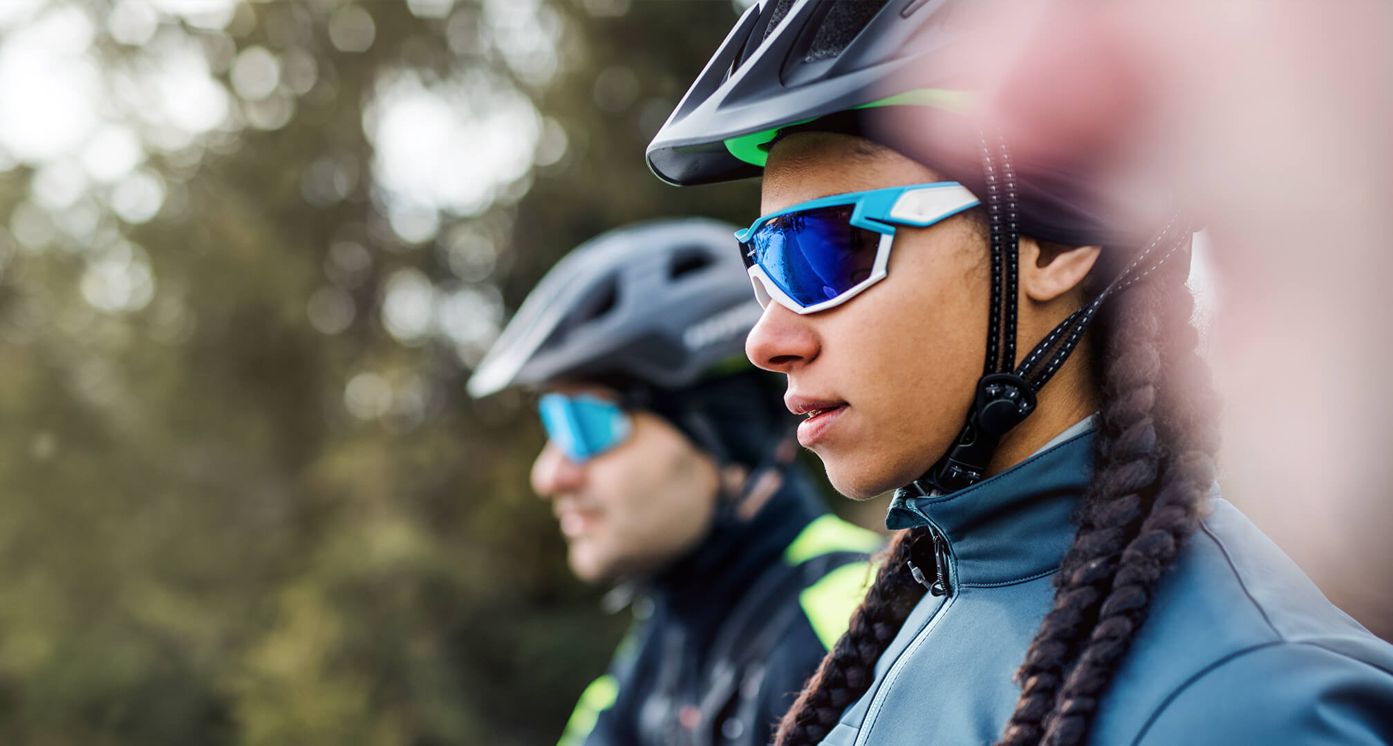 två personer med solglasögon som bär cykelhjälm